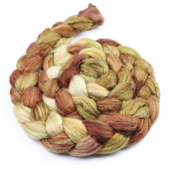A hand dyed fiber braid consisting of earthy shades of cream, mustard and rustic orange.